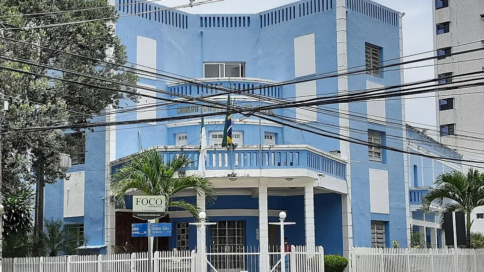 Fachada azul e branca do Palácio Padre Miguelinho, sede da Câmara Municipal de Natal, com bandeiras na sacada