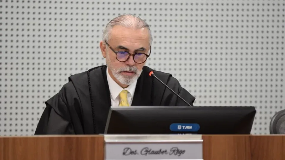 O desembargador Glauber Rêgo, de toga, sentado diante do microfone no Pleno do TJRN