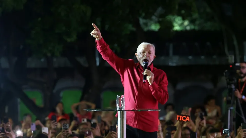 Lula, de camisa vermelha, discursa em ato político à noite