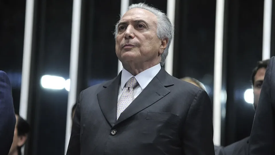 O ex-presidente Michel Temer, de terno escuro, em pé no plenário do Senado