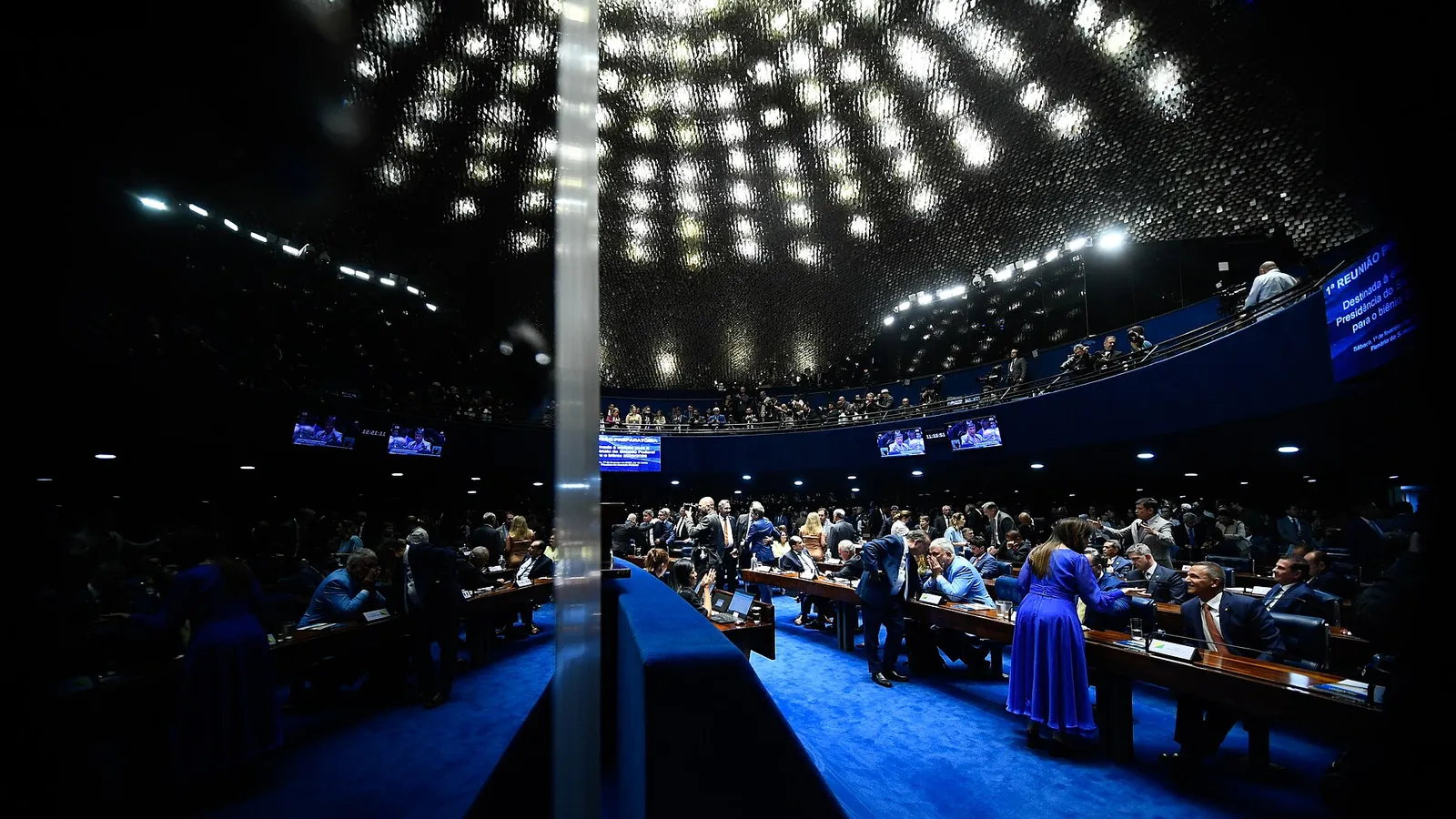 Vista geral do plenário do Senado Federal, com carpete azul e senadores nas bancadas