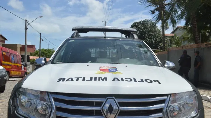 Viatura da Polícia Militar do Rio Grande do Norte estacionada, com policiais militares ao fundo